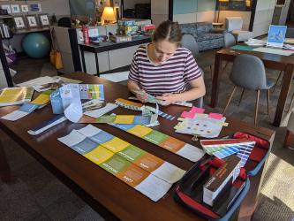 Woman designing pamphlets on table