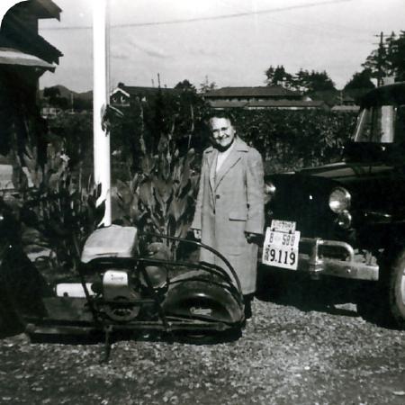 Mabel Francis, smiling next to a motorcycle