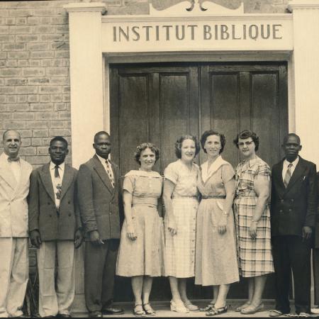 men and women standing in front of a Bible Institute